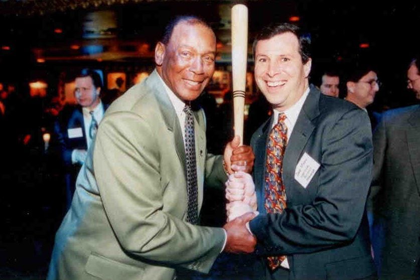 Two men holding a baseball bat